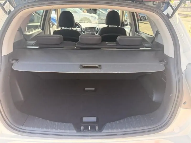 Vue arrière du coffre ouvert d'un SsangYong Tivoli blanc 2017, avec tablette cache-bagages et sièges arrière visibles.