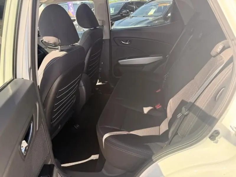 Vue intérieure arrière côté droit du SsangYong Tivoli blanc 2017, montrant les sièges arrière en tissu noir et les dossiers avant.