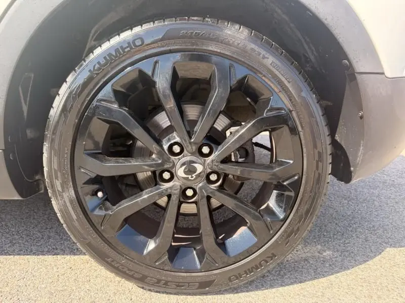 Gros plan sur la roue avant droite noire à jante alliage du SsangYong Tivoli blanc 2017 version Sport Bi-Ton.