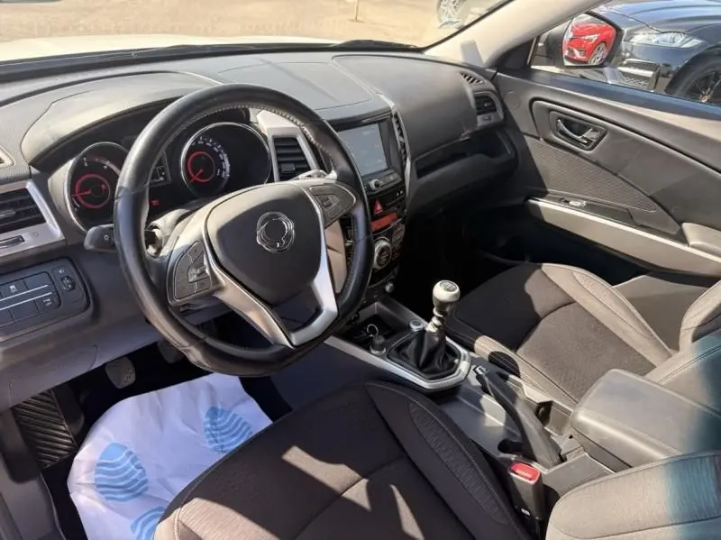 Vue intérieure côté conducteur du SsangYong Tivoli 2017, tableau de bord noir avec volant multifonction et boîte manuelle.