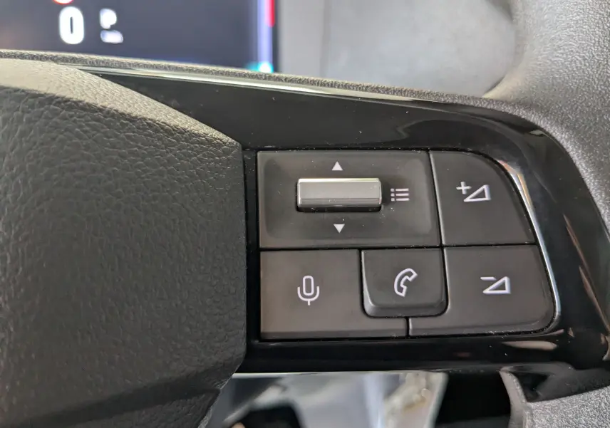 Gros plan sur les commandes au volant du Fiat Scudo Fourgon XL 145 EAT8 2024, boutons de volume et téléphone visibles.