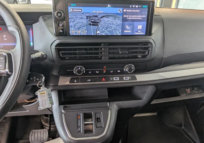 Vue intérieure du tableau de bord du Fiat Scudo Fourgon XL 145 EAT8 2024, avec écran tactile GPS et commandes de climatisation.