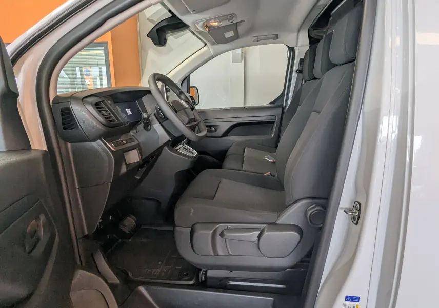 Intérieur du FIAT Scudo Fourgon XL 145 EAT8 blanc 2024, vue côté conducteur avec sièges noirs et tableau de bord moderne.