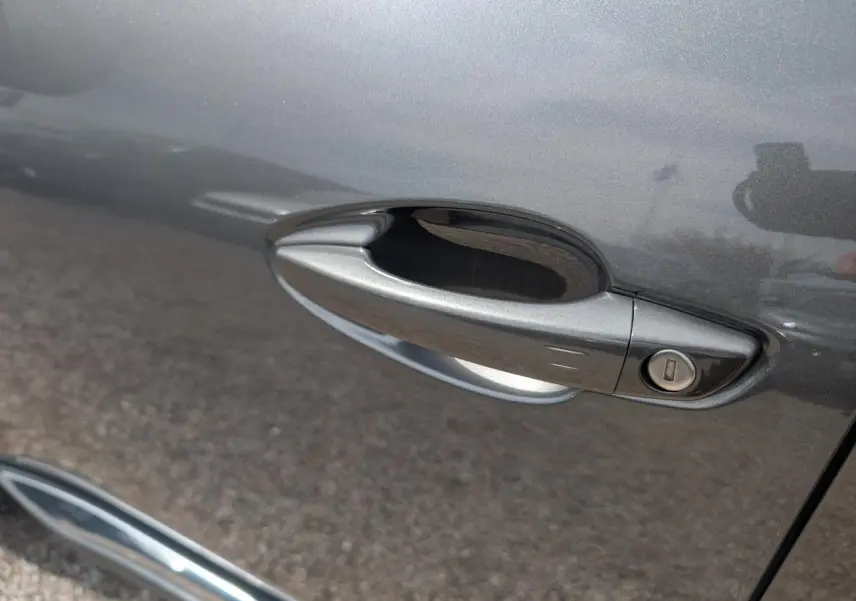 Poignée de porte côté droit gris métallisé du Peugeot 5008 2023 version GT avec serrure intégrée.