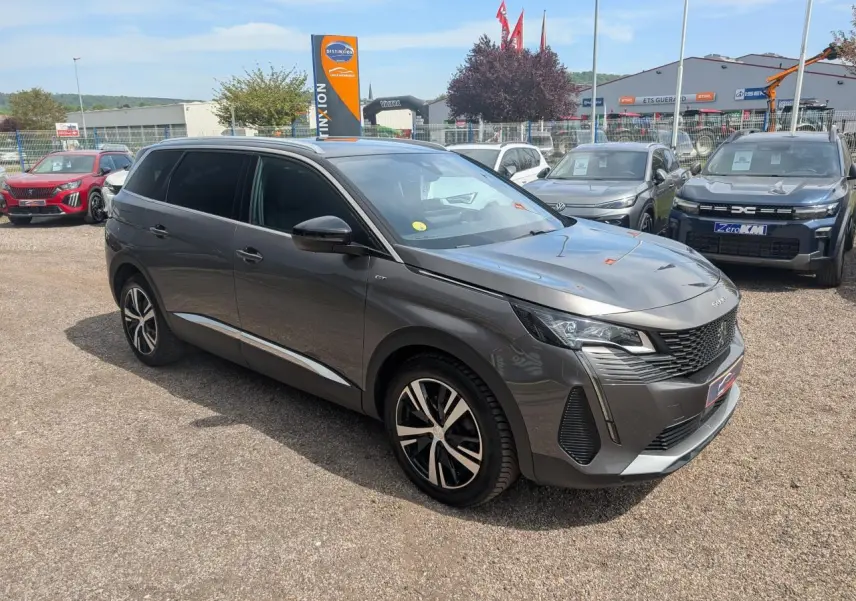 Peugeot 5008 gris métallisé vue 3/4 avant droit, calandre GT chromée et jantes alliage bi-ton 18 pouces.
