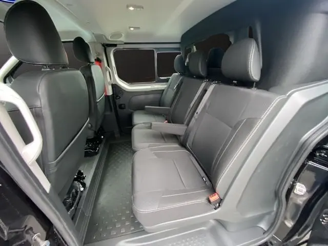 Vue intérieure côté droit du Renault Trafic Cabine Approfondie 2025 noir, montrant les trois sièges indépendants en cuir gris.