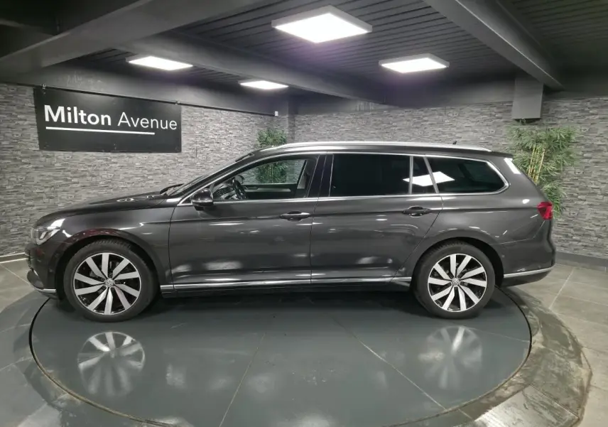 Profil côté gauche d'une Volkswagen Passat SW gris métallisé avec jantes alliage 18 pouces Dartford dans un showroom.