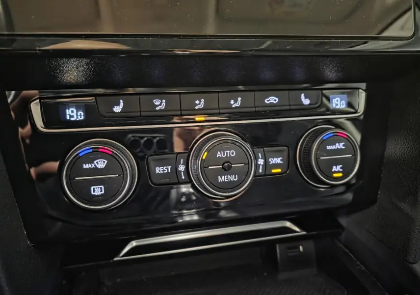 Panneau de commande de la climatisation automatique tri-zone noir brillant dans une Volkswagen Passat SW gris 2019.