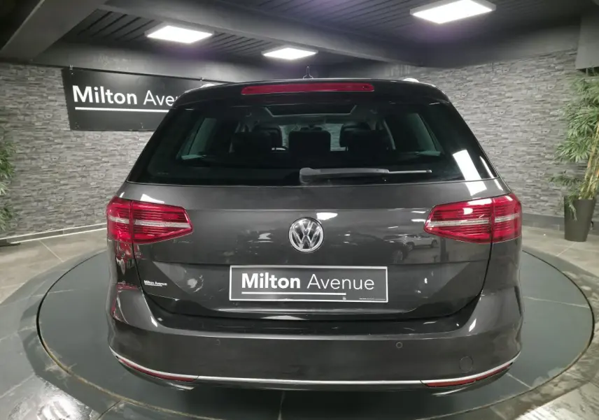 Vue arrière d'un break Volkswagen Passat gris métallisé avec feux arrière LED et logo VW centré.