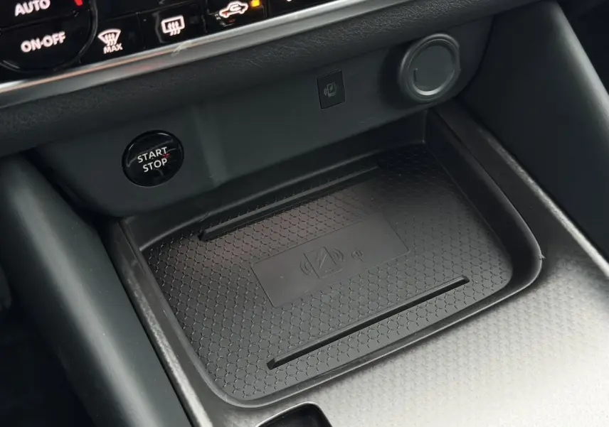 Gros plan sur la console centrale du Nissan Qashqai 2025, zone de charge sans fil et bouton Start/Stop noir.