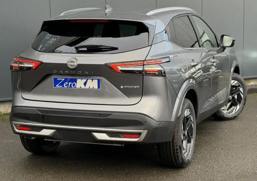 Vue 3/4 arrière droite du Nissan Qashqai 2025 gris Squale avec feux LED et jantes alliage noires distinctives.