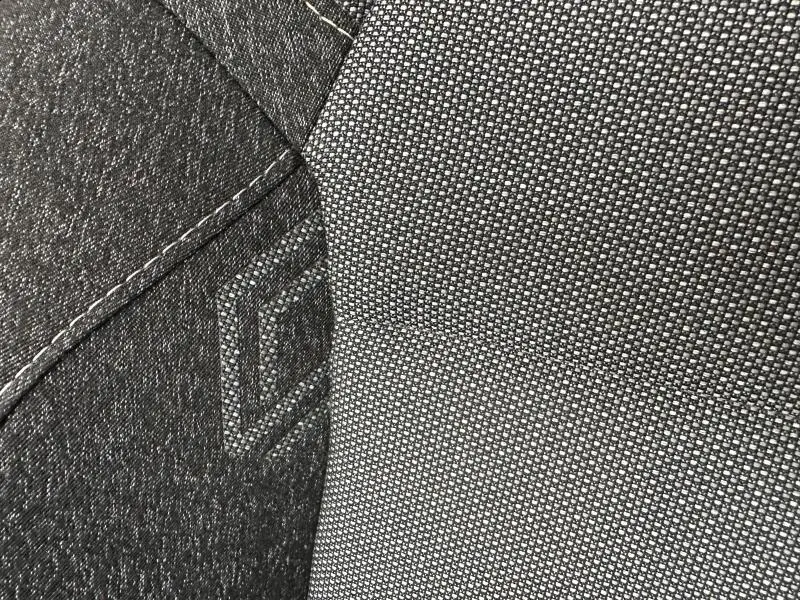 Gros plan sur le tissu gris texturé et la couture noire d’un siège de Renault Captur 2025, version Techno.
