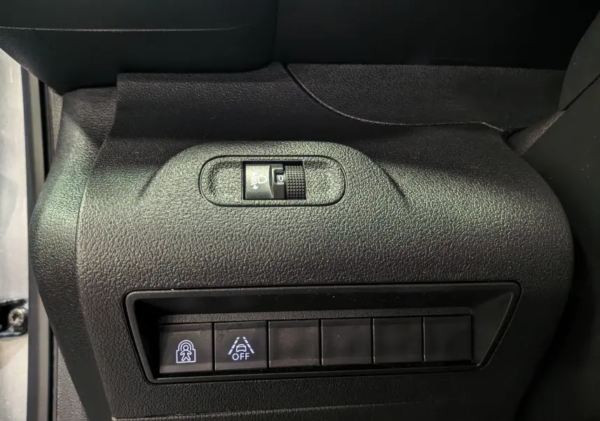 Vue rapprochée du tableau de bord côté gauche du Peugeot Rifter gris Artense, avec commandes d’éclairage et d’aide à la conduite.