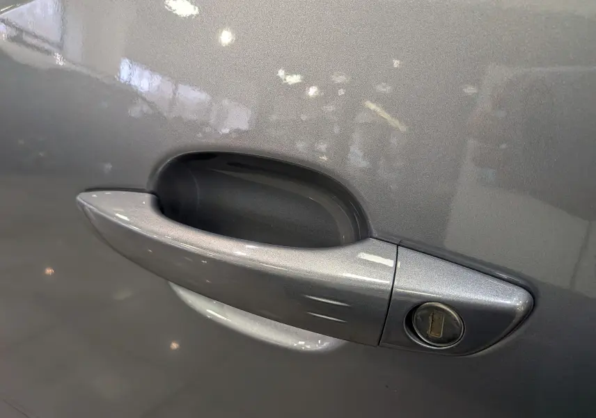 Poignée de porte côté gauche gris Artense du Peugeot Rifter 2024 BlueHDi 130 GT avec serrure visible en gros plan.