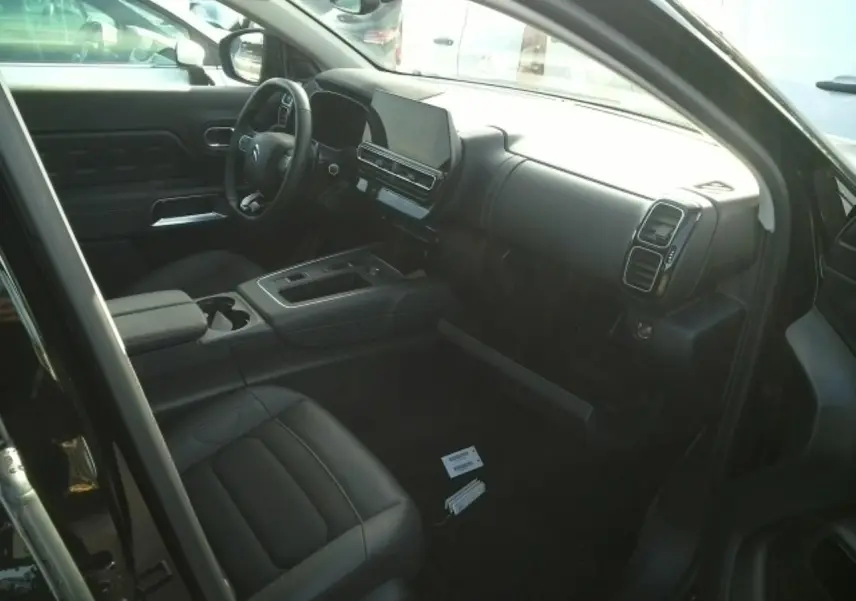 Intérieur noir du Citroën C5 Aircross 2024 vu côté conducteur, avec tableau de bord moderne et écran tactile central.