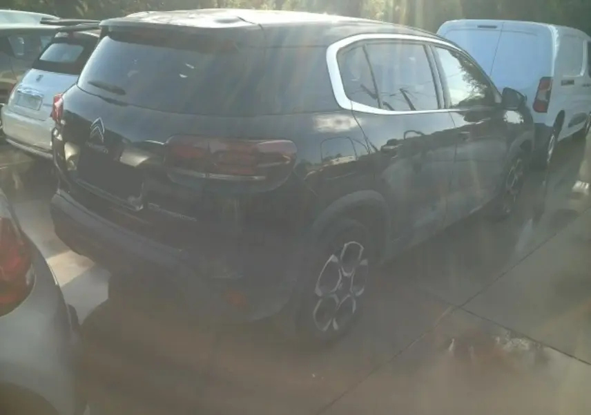 Vue 3/4 arrière droite d'un Citroën C5 Aircross 2024 noir Perla avec jantes alliage et toit bi-ton noir.