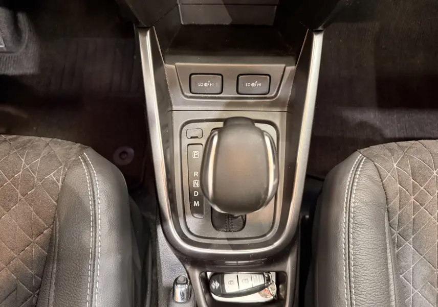 Vue plongeante sur la console centrale du Suzuki Vitara 2023, avec levier de boîte auto et sièges en cuir noir.