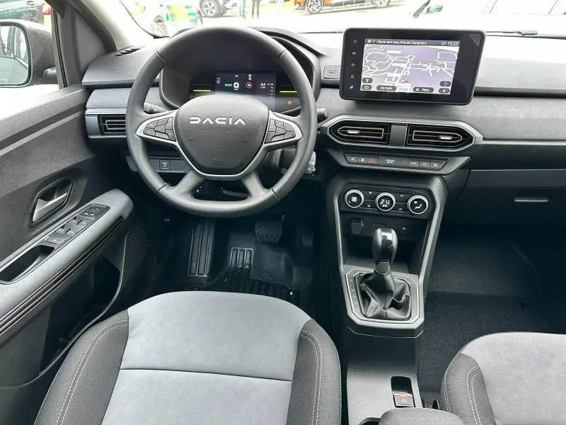 Vue intérieure frontale du poste de conduite du Dacia Jogger 1.6 hybrid noir nacré, avec volant multifonctions et écran tactile central.