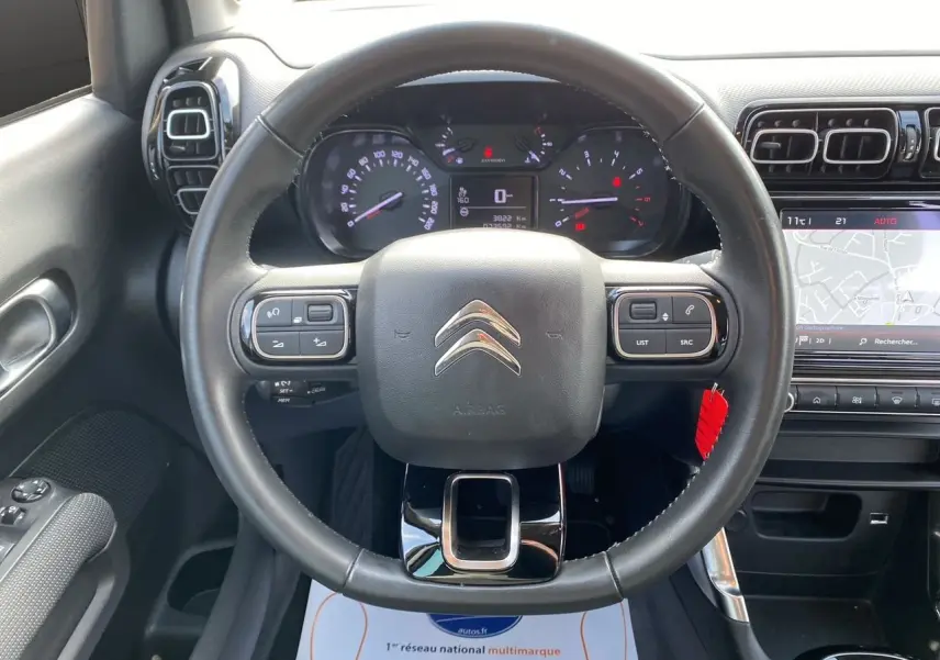 Vue intérieure centrée sur le volant noir du Citroën C3 Aircross 2022 avec tableau de bord et écran tactile gris.