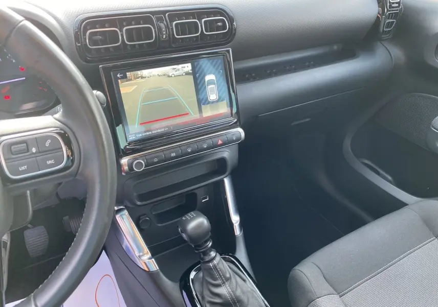 Vue intérieure côté conducteur du tableau de bord gris noir de la Citroën C3 Aircross 2022 avec écran affichant la caméra de recul.