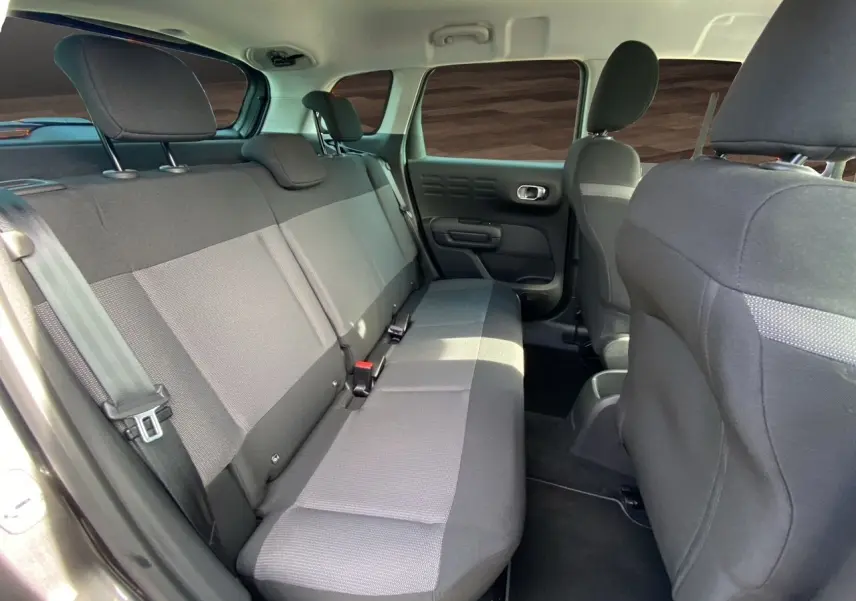 Vue intérieure arrière côté gauche du Citroën C3 Aircross 2022, sièges tissu gris et noir, habitacle spacieux.
