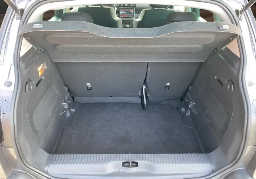 Coffre ouvert vu de l’arrière d’une Citroën C3 Aircross gris platinium avec intérieur sombre et tablette de coffre relevée.