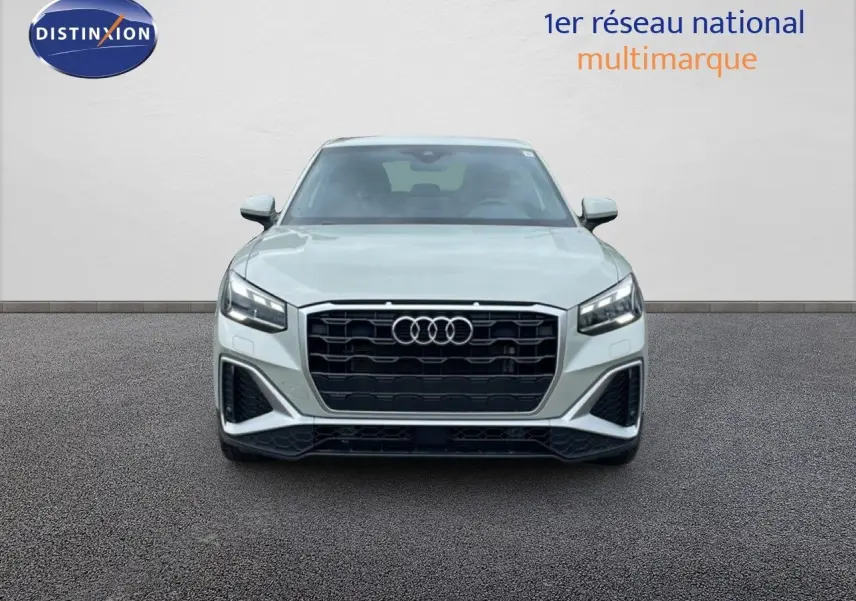 Vue frontale d'un Audi Q2 35 2.0 TDI S-Line en argent rose métal avec calandre noire et phares LED allumés.