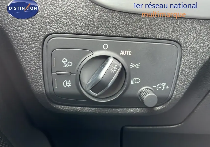 Commande des phares en gros plan à l'intérieur d'un Audi Q2 35 2.0 TDI S-Line, finition argent rose métal.