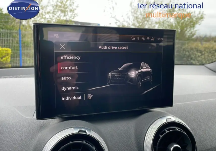 Écran central de l'Audi Q2 35 2.0 TDI S-Line affichant les modes de conduite, intérieur noir visible.