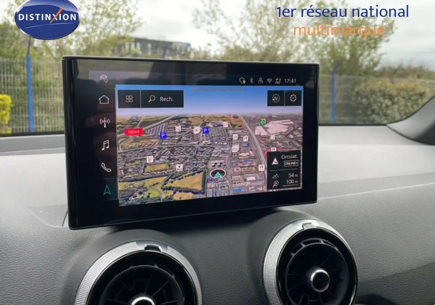 Vue avant intérieure du tableau de bord de l'Audi Q2 2025 avec écran tactile GPS et aérateurs ronds argentés.