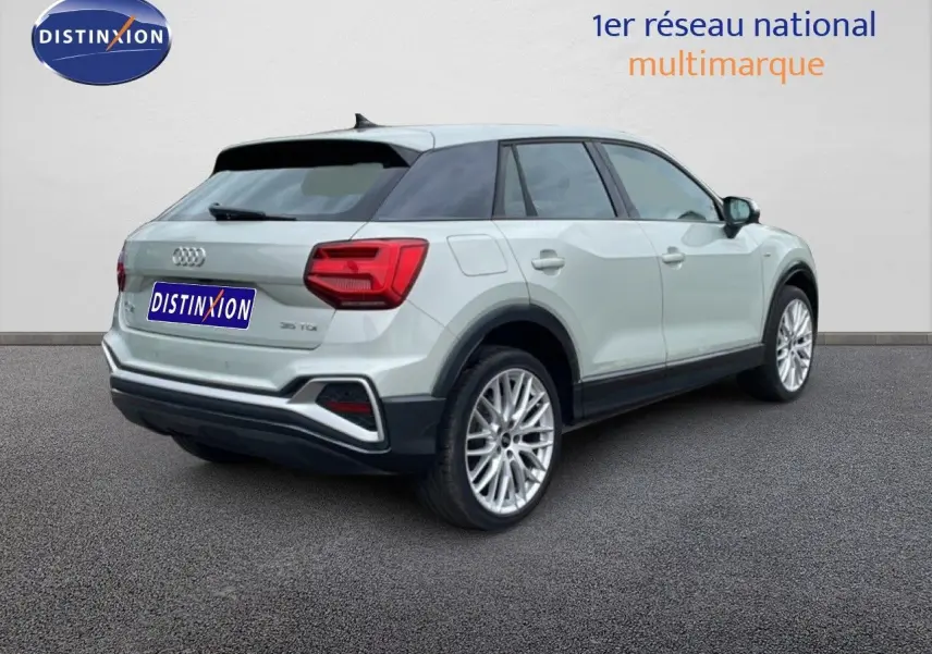 Audi Q2 35 2.0 TDI S-Line argent rose métal en 3/4 arrière droit, jantes alliage et toit noir contrasté.