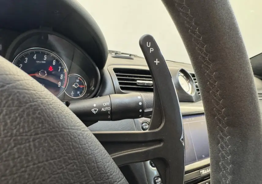 Gros plan sur le volant en daim gris foncé et la palette de changement de vitesse de la Maserati Granturismo S 4.7 de 2010.