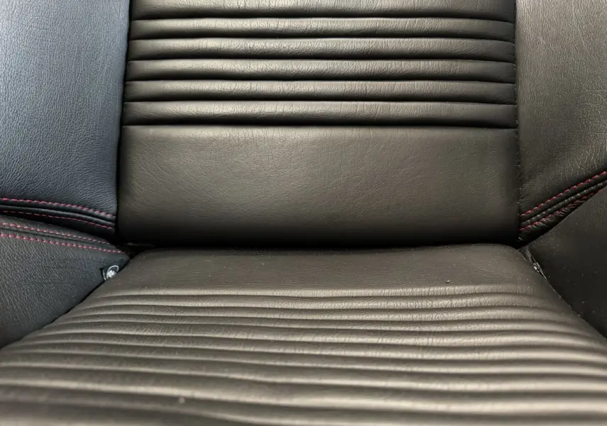 Gros plan sur la sellerie en cuir noir avec surpiqûres rouges de la Maserati Granturismo S 4.7 gris foncé.
