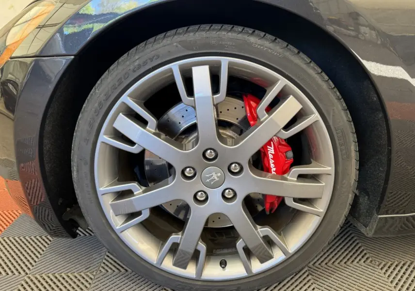 Gros plan sur la roue avant droite grise d'une Maserati Granturismo S 4.7 avec étrier de frein rouge marqué Maserati.