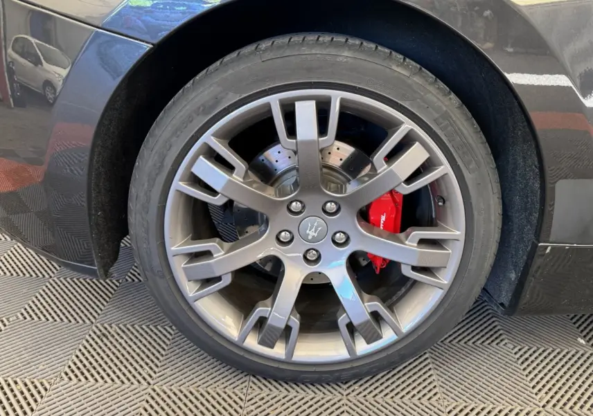 Gros plan sur la roue avant droite gris foncé d'une Maserati Granturismo S 4.7 avec étrier de frein rouge visible.