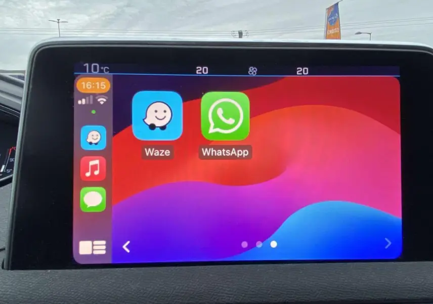 Écran tactile intérieur du Peugeot 3008 affichant les applications Waze et WhatsApp, vue frontale rapprochée.