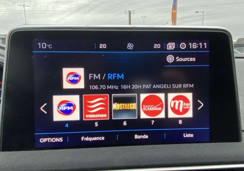 Écran tactile central du Peugeot 3008 2017 montrant les stations radio, avec tableau de bord et pare-brise en arrière-plan.
