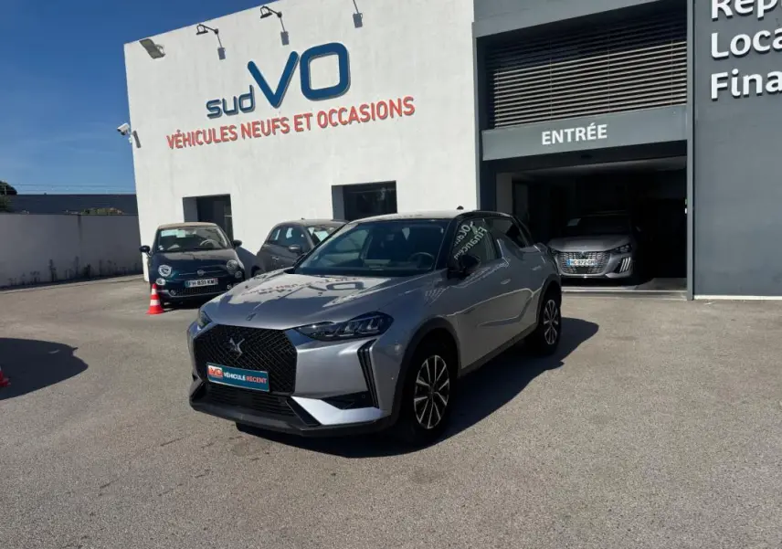 DS3 100 BVM6 Bastille gris 2024 en 3/4 avant droit, avec jantes alliage 18 pouces, stationné devant un garage sud VO.