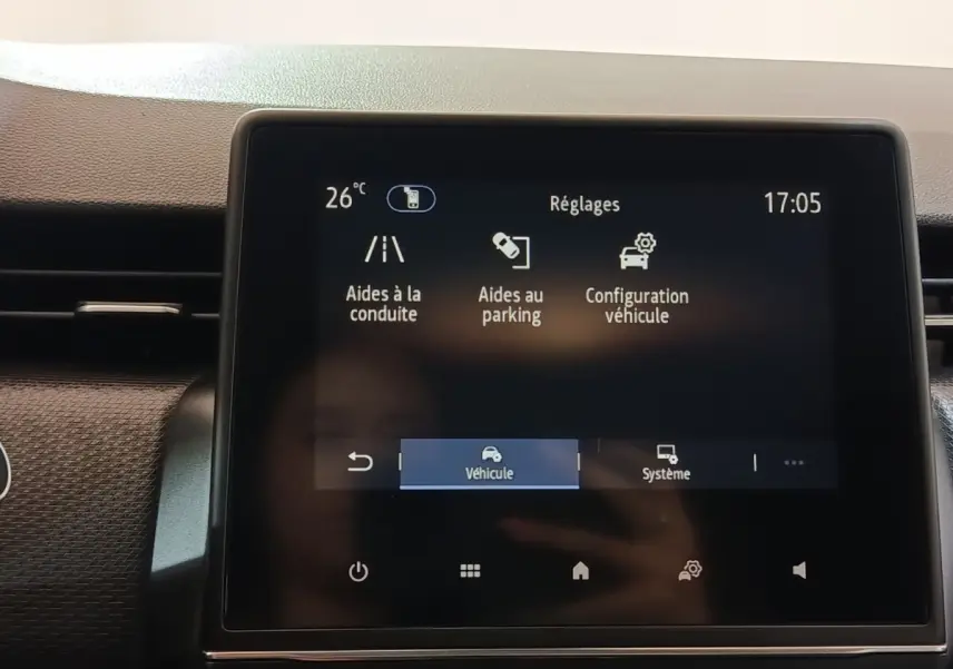 Écran tactile central de la Renault Clio Business E-TECH 140 blanc, affichant les réglages d’aides à la conduite.