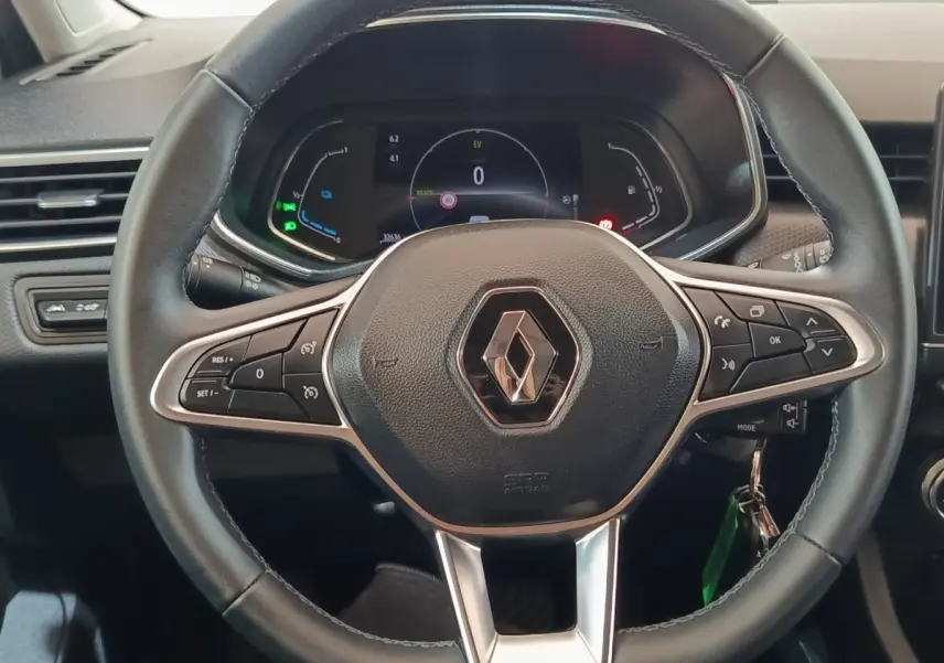 Vue rapprochée du volant noir de la Renault Clio Business E-TECH 140 2021 avec tableau de bord numérique allumé.