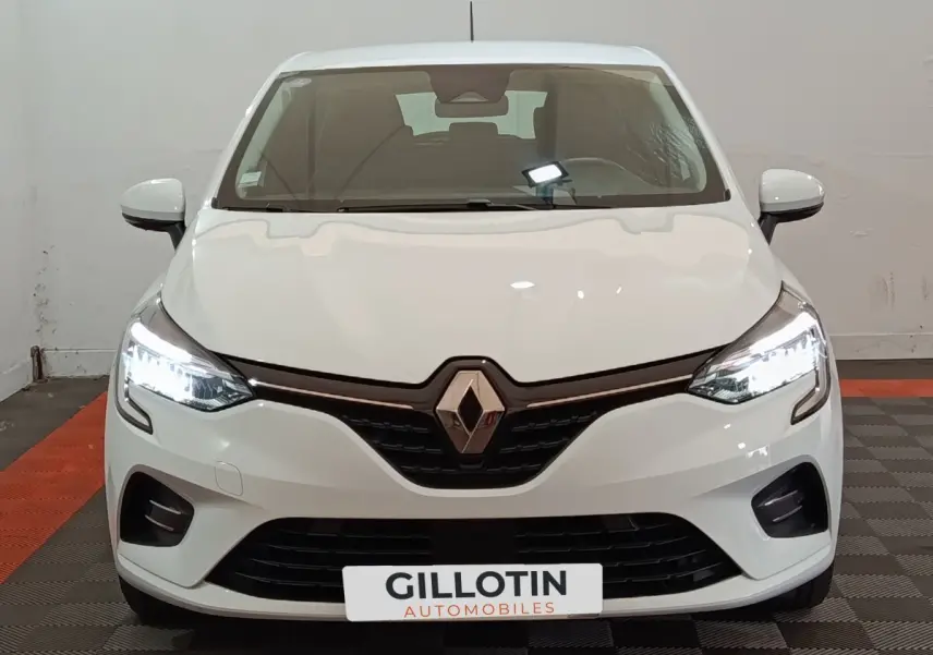 Vue de face d'une Renault Clio Business E-TECH 140 blanche avec phares LED allumés et calandre noire.