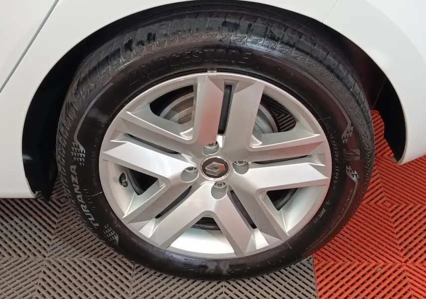 Gros plan sur la roue avant droite blanche d'une Renault Clio Business E-TECH 140 avec jante alliage et pneu Bridgestone.