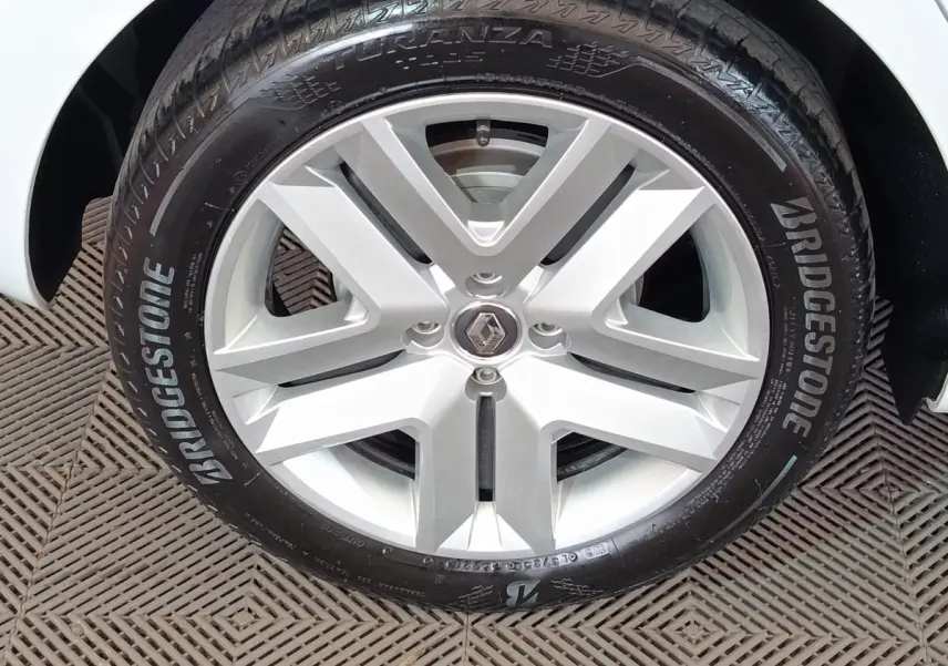Gros plan sur la jante alliage argentée et le pneu Bridgestone d'une Renault Clio blanche.