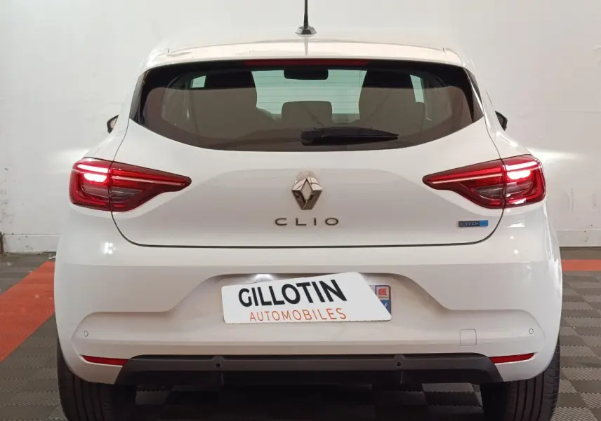 Vue arrière d'une Renault Clio Business E-TECH 140 blanche avec feux LED allumés et logo distinctif E-TECH.