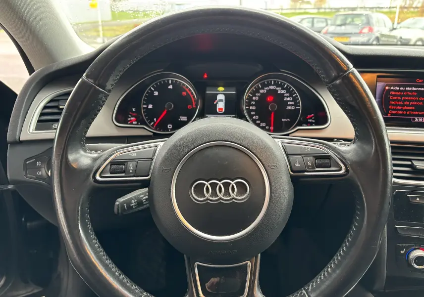 Vue intérieure centrée sur le volant en cuir noir d'une Audi A5 Sportback 2013 avec tableau de bord et affichage numérique.