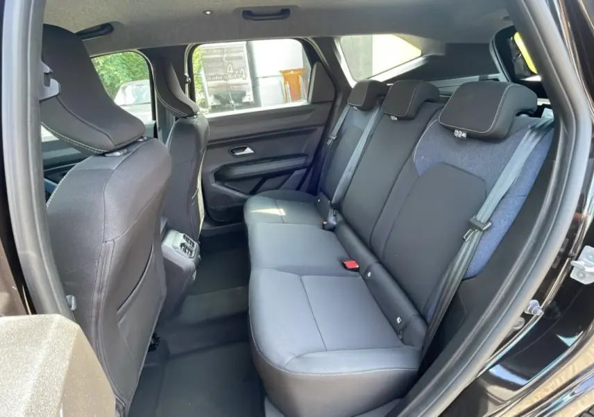 Vue intérieure sur la banquette arrière du Dacia Bigster 2025 noir perle, avec sièges tissu noir et ceinture grise.