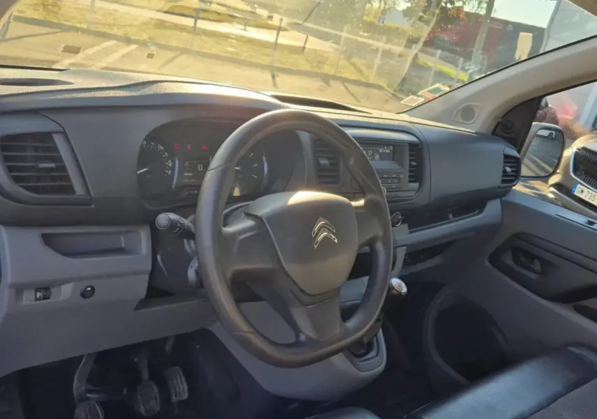 Vue intérieure du tableau de bord et volant du Citroën Jumpy blanc, version fourgon diesel 2019 avec boîte manuelle.