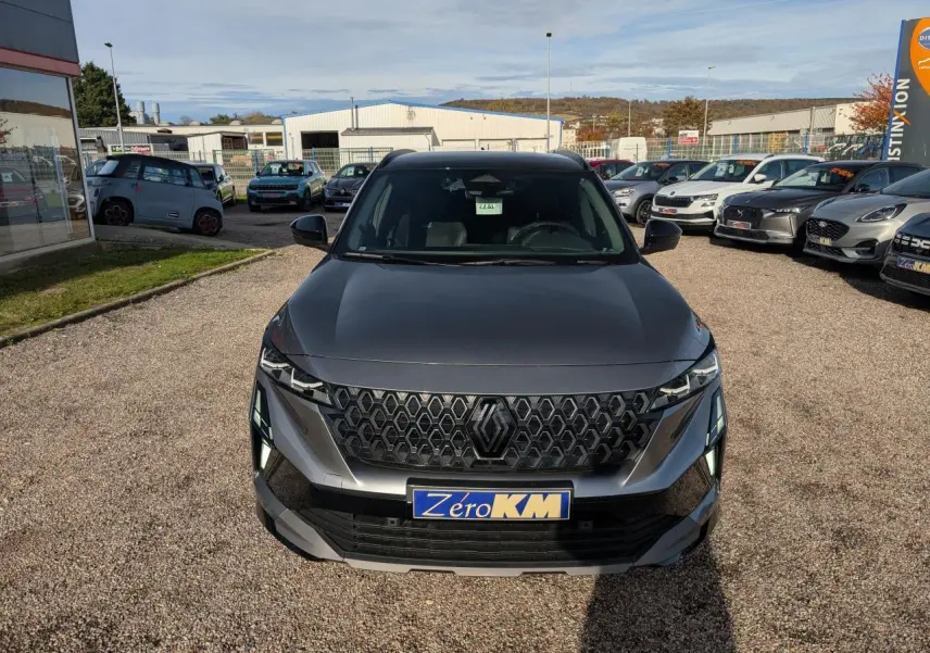 Vue avant d'un Renault Austral gris métallisé avec calandre noire et plaque Zéro KM visible.