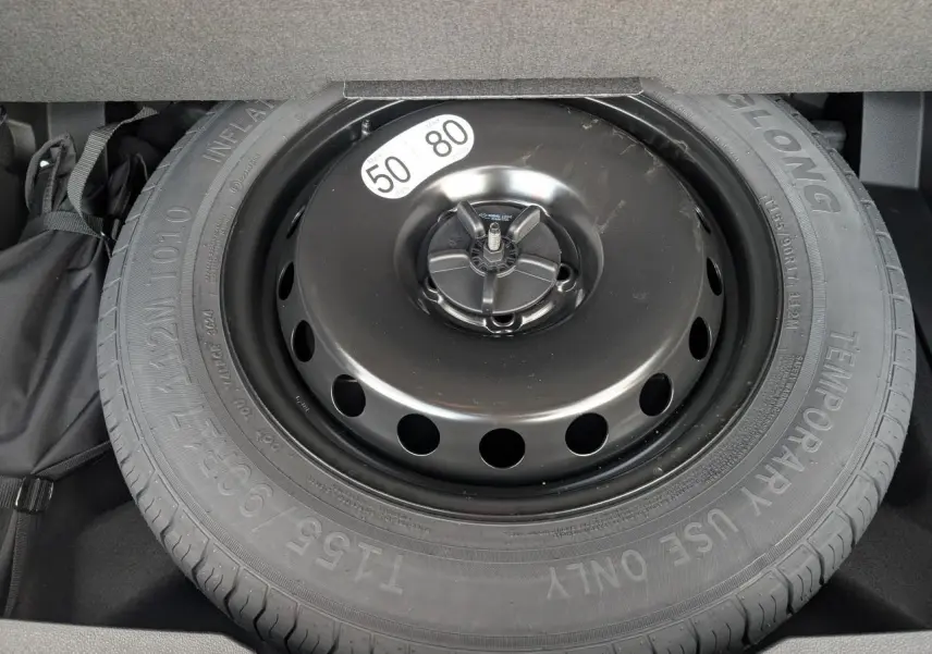 Gros plan sur la roue de secours temporaire noire dans le coffre du Renault Austral gris métallisé 2025.