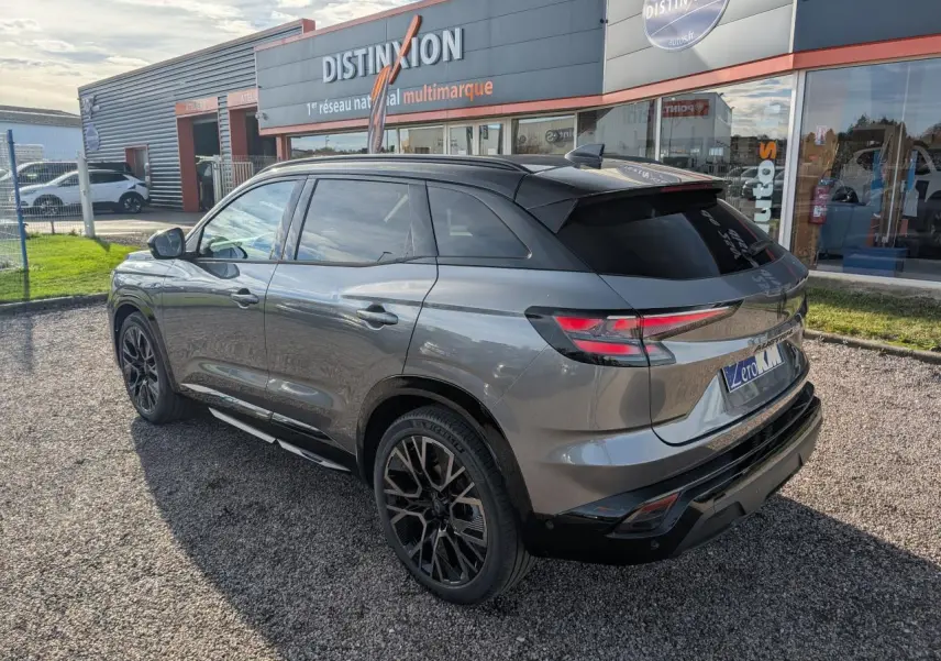 Vue 3/4 arrière droite du Renault Austral gris métallisé avec toit noir étoilé et jantes alliage noires.